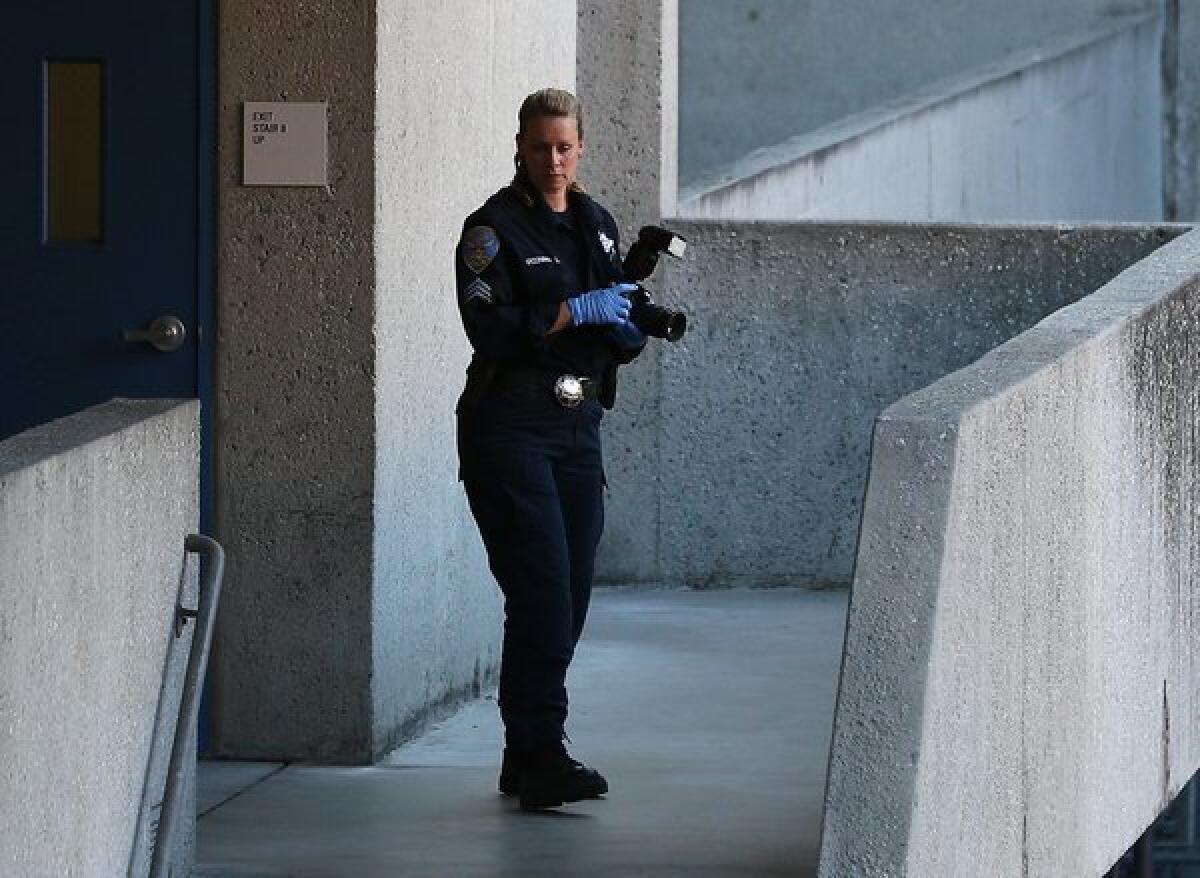 A San Francisco police officer inspects an outdoor stairwell at San Francisco General Hospital on Tuesday where a body was found.