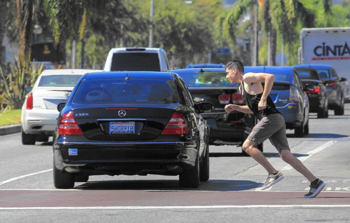 A man runs across Santa Monica Boulevard at San Vicente Boulevard in West Hollywood. Since 2011, there have been 84 vehicle and pedestrian collisions in West Hollywood crosswalks.