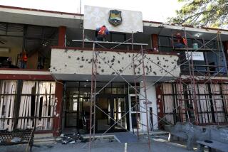 FILE - Workers repair the entrance of City Hall riddled in large bullet holes in Villa Union, Mexico, Dec. 2, 2019, after 22 people were killed in a weekend gun battle between a drug cartel and security forces. Mexico wants an urgent investigation into how U.S. military-grade weapons are increasingly being found in the hands of Mexican drug cartels, Mexico's top diplomat said on Jan. 22, 2024. (AP Photo/Eduardo Verdugo, File)