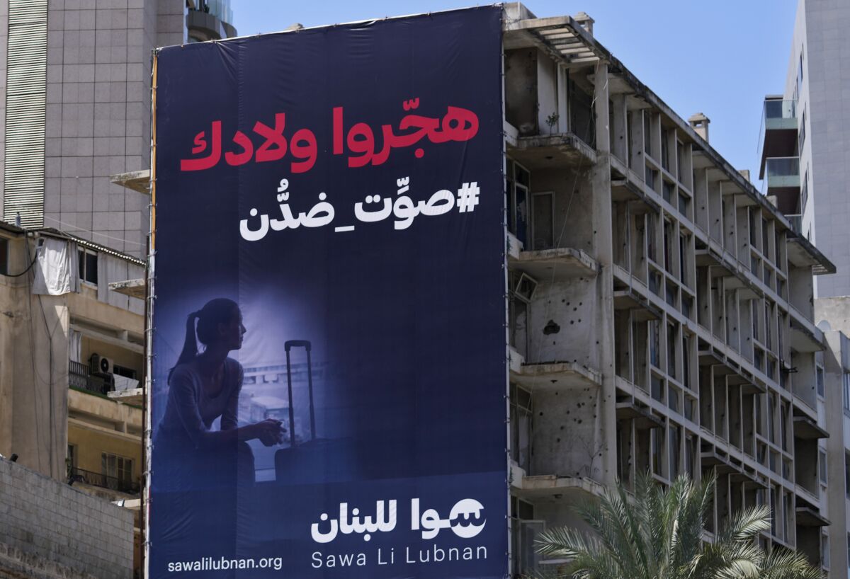 A giant electoral billboard for the upcoming parliamentary elections, hangs on an abandoned building, in Beirut, Lebanon, April 11, 2022. The nationwide vote on May 15 is the first since Lebanon's economy took a nosedive and an August 2020 explosion at Beirut's port killed more than 200 and destroyed parts of the capital. Lebanon's various disasters have fueled anger at Lebanon's political elite, but few see any hope that elections will dislodge them. Arabic reads: "They displaced your children, vote against them." (AP Photo/Hussein Malla)