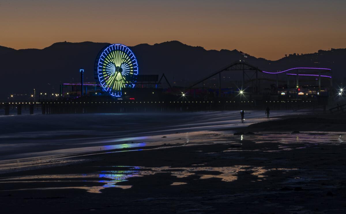 The Ferris wheel begins to change to patriotic colors at dusk on the Santa Monica Pier for the July 4 holiday weekend.