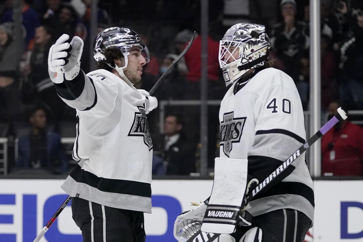 Defenseman Sean Durzi congratulates goalie Cal Petersen after the Kings defeated the New York Islanders.