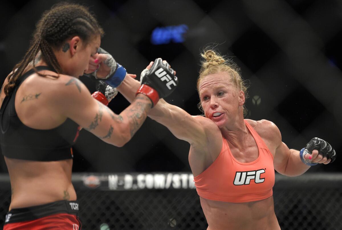 Holly Holm, right, punches Raquel Pennington during a bantamweight fight at UFC 184 on Feb. 28.