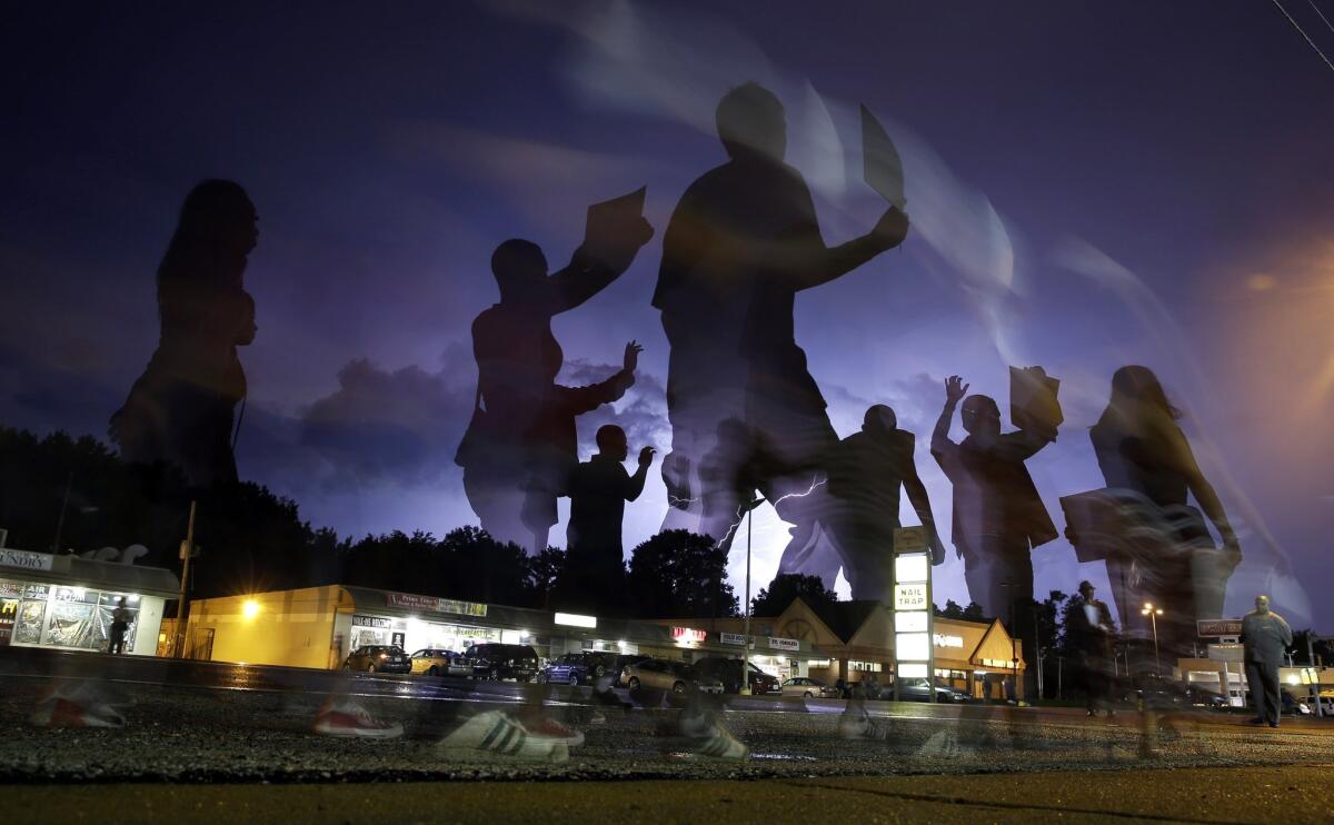 Demonstrators march in Ferguson, Mo. On Aug. 9, a white police officer fatally shot Michael Brown, an unarmed black 18-year old, in the St. Louis suburb.