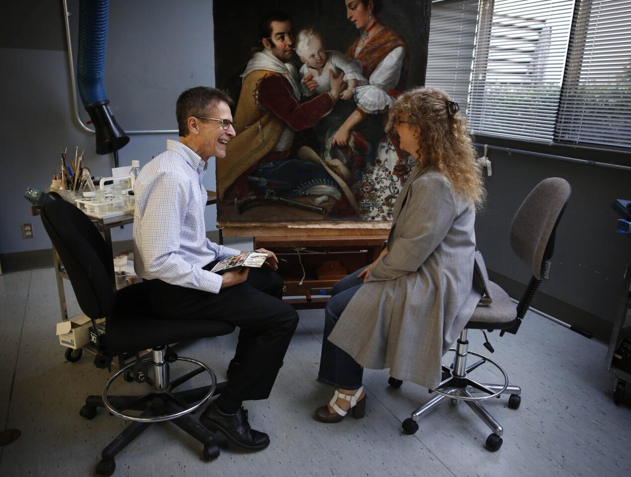 Joseph Fronek, senior paintings conservator and head of paintings conservation, sits with curator Ilona Katzew at LACMA, where one of the 16 scroll casta paintings by 18th century Mexican artist Miguel Cabrera was restored.