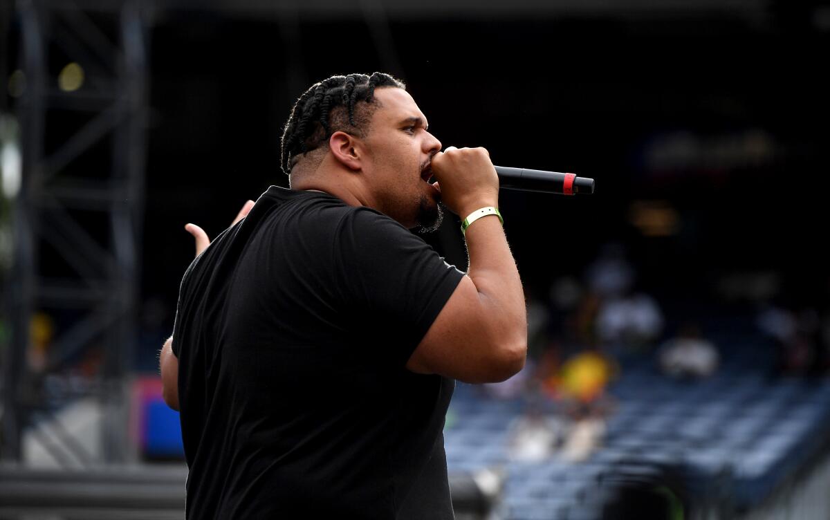 Rapper BeatKing holding a mic to his mouth wearing a dark T-shirt. 