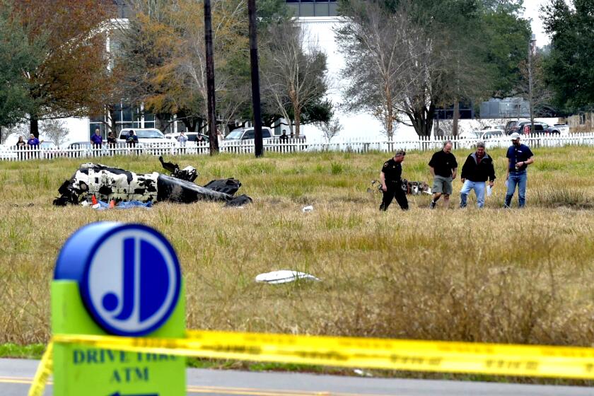 Investigators look over the site of a plane crash near Feu Follet Road and Verot School Road in Lafayette, La., Saturday, Dec. 28, 2019. Authorities confirmed the accident but details on whether anyone was injured was not immediately known.(Scott Clause/The Lafayette Advertiser via AP)