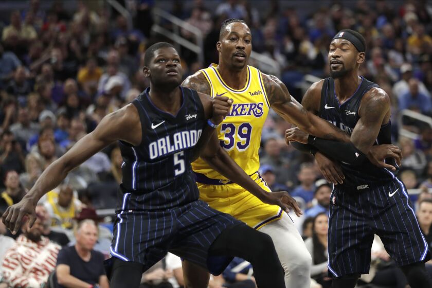 Los Angeles Lakers center Dwight Howard (39) works to get position between Orlando Magic's Mo Bamba (5) and Terrence Ross, right, during the first half of an NBA basketball game, Wednesday, Dec. 11, 2019, in Orlando, Fla. (AP Photo/John Raoux)