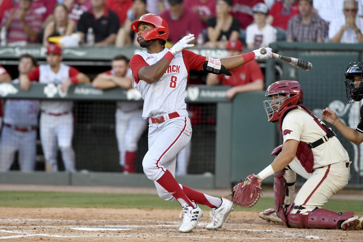 FILE - North Carolina State's Jose Torres (8) watches the ball after connecting for a home run against Arkansas in the ninth inning during an NCAA college baseball super regional game in Fayetteville, Ark., in this Sunday, June 13, 2021, file photo. Home runs — lots and lots of them — have defined the NCAA baseball tournament so far. A total of 381 have been hit in 123 games, the highest total through super regionals since at least 2005.(AP Photo/Michael Woods, File)
