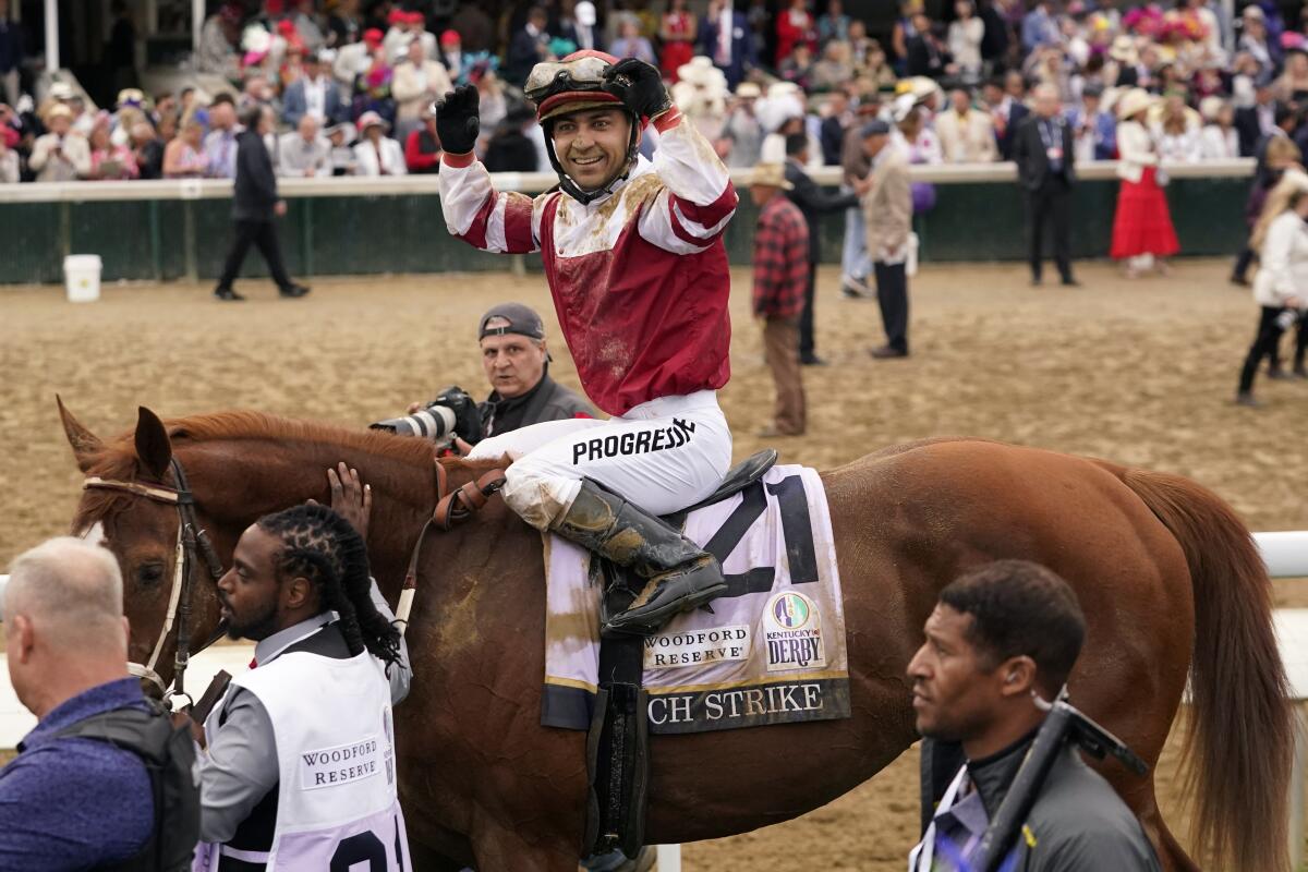 Sonny Leon celebrates atop Rich Strike after winning the Kentucky Derby on Saturday.