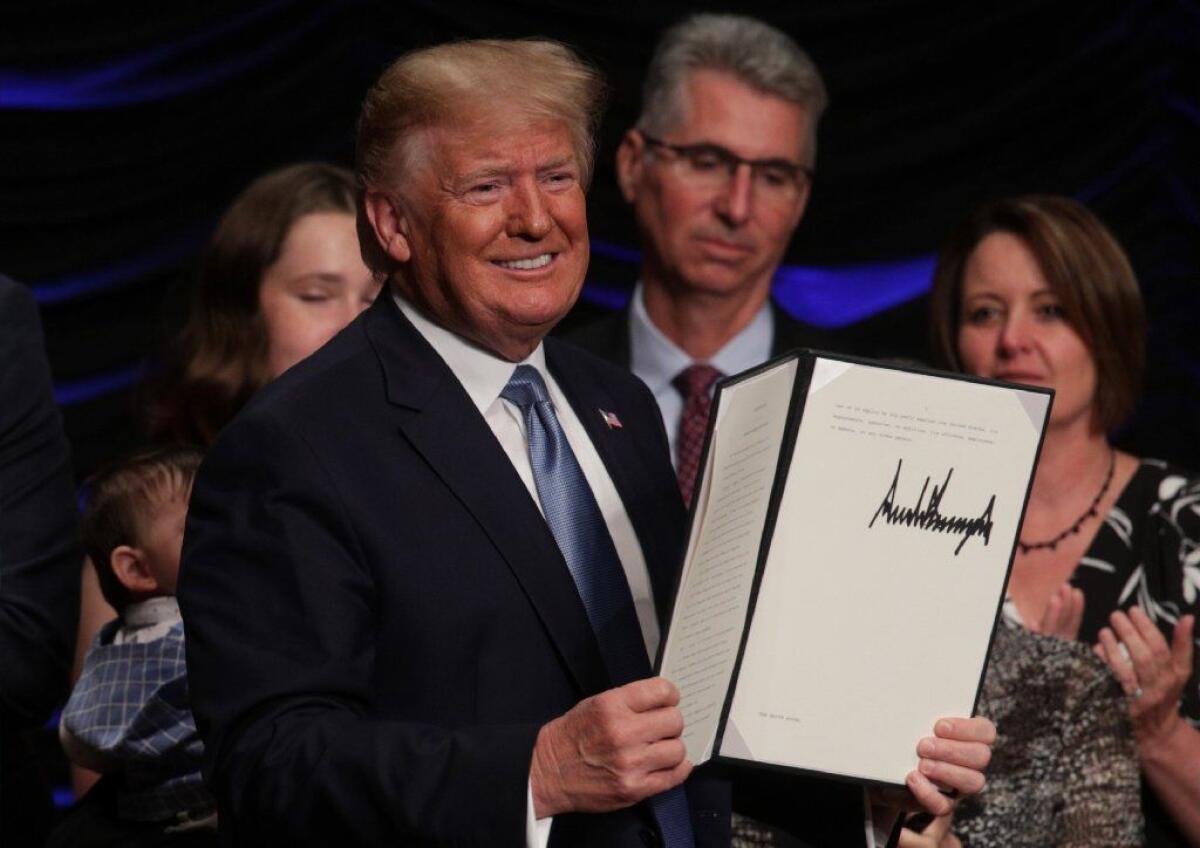 President Trump displays an executive order he signed Wednesday.
