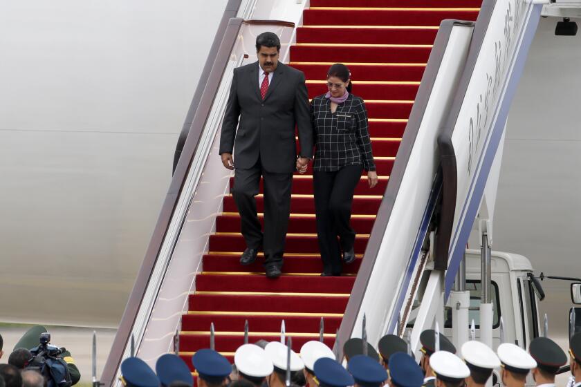 FILE - Venezuela's President Nicolas Maduro, left, and first lady Cilia Flores arrive at Beijing Capital International Airport in Beijing, China, Sept. 1, 2015. (AP Photo/Ng Han Guan, File)