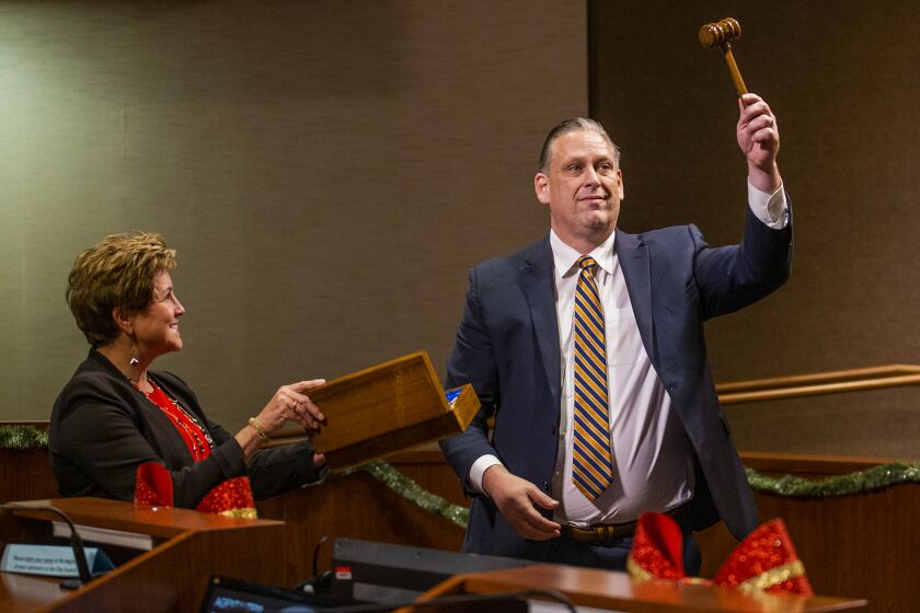 Huntington Beach, CA - December 06: Outgoing Mayor Barbara Delgleize presents the gavel to newly selected Mayor Tony Strickland during the swearing in ceremony for city council members at the Huntington Beach City Hall on Tuesday, Dec. 6, 2022. (Scott Smeltzer / Daily Pilot)