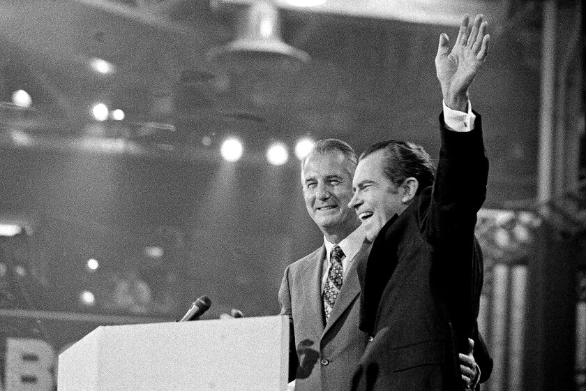 With Vice-president Spiro T. Agnew at his side, U.S. President Richard M. Nixon waves to the Republican National Convention delegates just before accepting the nomination for re-election in Miami, Fla., Aug. 23, 1972. (AP Photo)