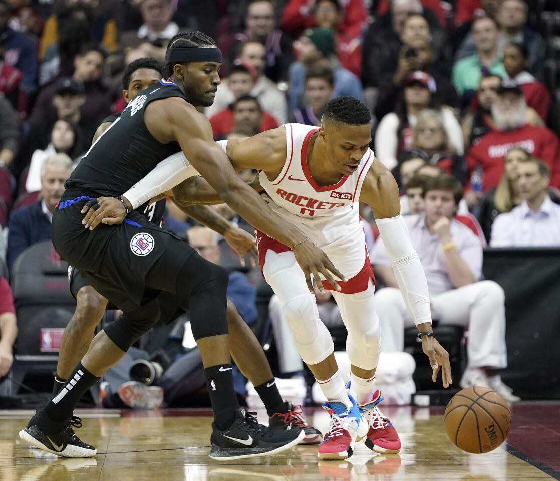 Rockets guard Russell Westbrook (0) keeps the ball away from Clippers forward Maurice Harkless during the first half of a game Nov. 13.