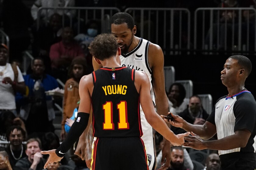 Atlanta Hawks guard Trae Young (11) and Brooklyn Nets forward Kevin Durant exchange words during the second half of an NBA basketball game Friday, Dec. 10, 2021, in Atlanta. (AP Photo/John Bazemore)