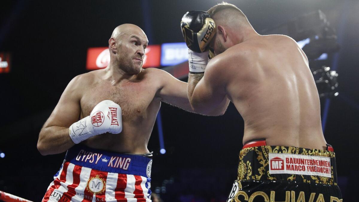 Tyson Fury, left, punches Tom Schwarz during their heavyweight boxing match in Las Vegas on Saturday. Fury won by TKO in the second round.