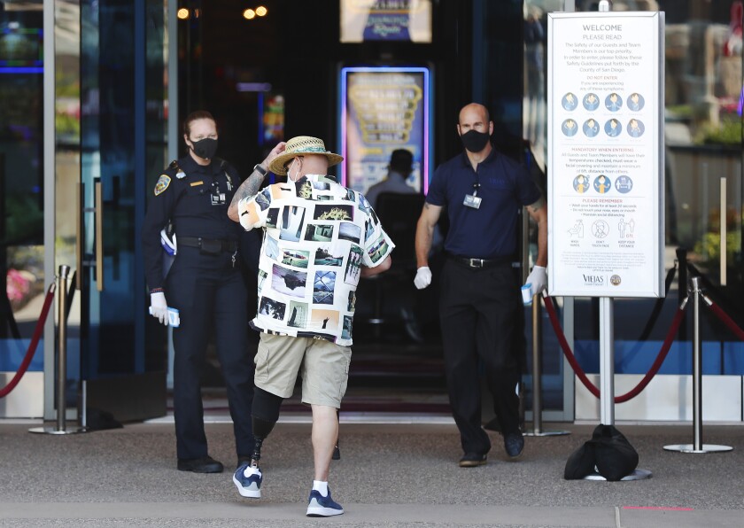 Hugh Henson gets his temperature checked as he heads into Viejas Casino & Resort after it reopened to the public Monday, despite concerns from San Diego County and state health officials.