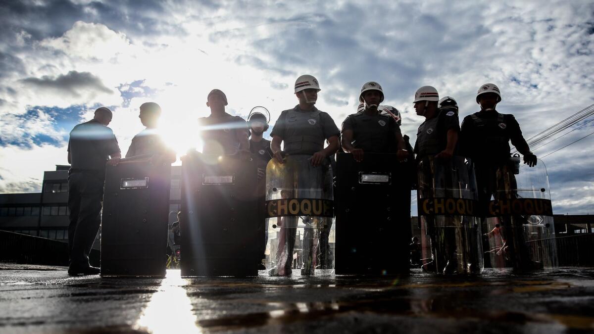Police stand guard in March in Sao Paulo. Authorities in Brazil's most populous city are investigating two shootings that left nine dead in a single night.