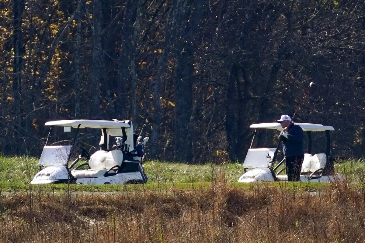 President Trump follows through on a swing at his golf course Saturday morning 