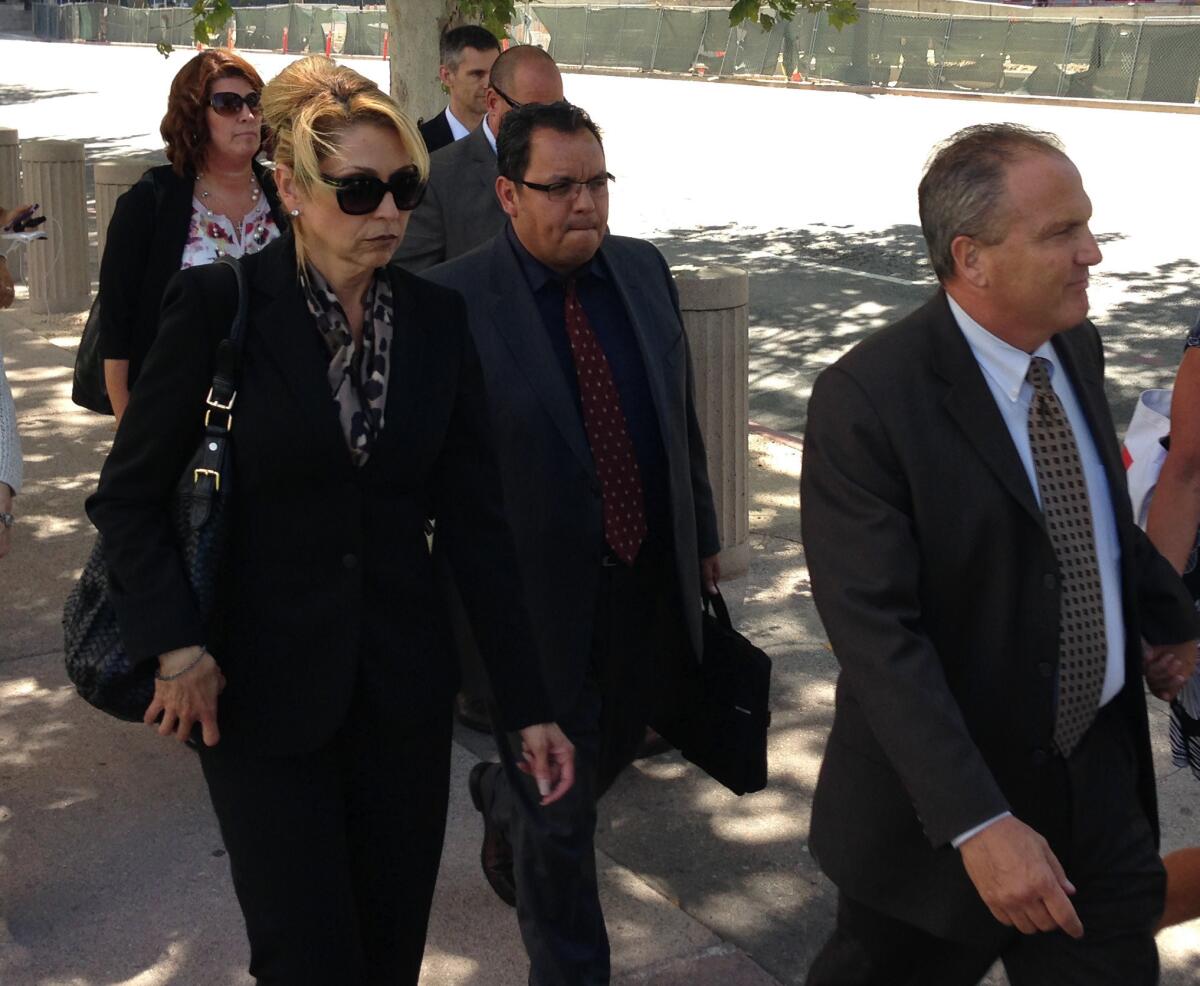 Sgt. Maricela Long, left and Lt. Stephen Leavins, far right leave the federal courthouse in downtown Los Angeles.