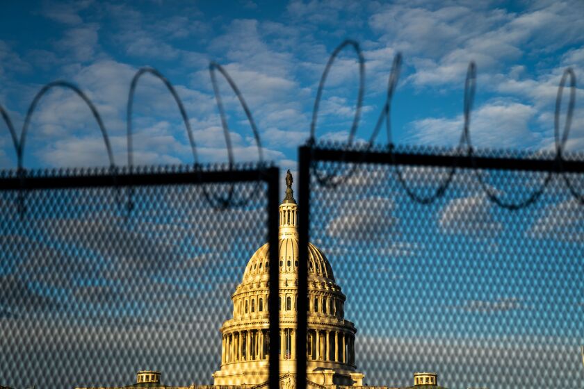 WASHINGTON, DC - JANUARY 16: Barbed wire, is seen atop security fencing, with the dome of the U.S. Capitol Building on Saturday, Jan. 16, 2021 in Washington, DC. After last week's riots and security breach at the U.S. Capitol Building, the FBI has warned of additional threats in the nation's capital and across all 50 states. (Kent Nishimura / Los Angeles Times)
