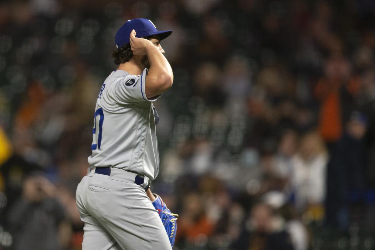 Los Angeles Dodgers starting pitcher Trevor Bauer cups his hand around his ear, taunting Giants fans booing him 