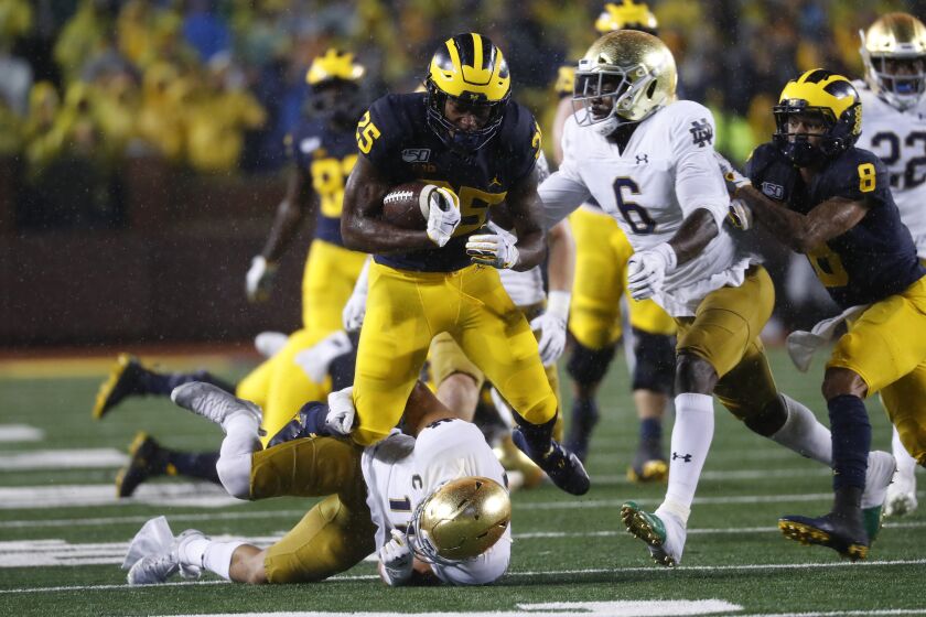 Michigan running back Hassan Haskins (25) runs over Notre Dame safety Alohi Gilman (11) during a 20-yard gain in the first half of an NCAA college football game in Ann Arbor, Mich., Saturday, Oct. 26, 2019. (AP Photo/Paul Sancya)