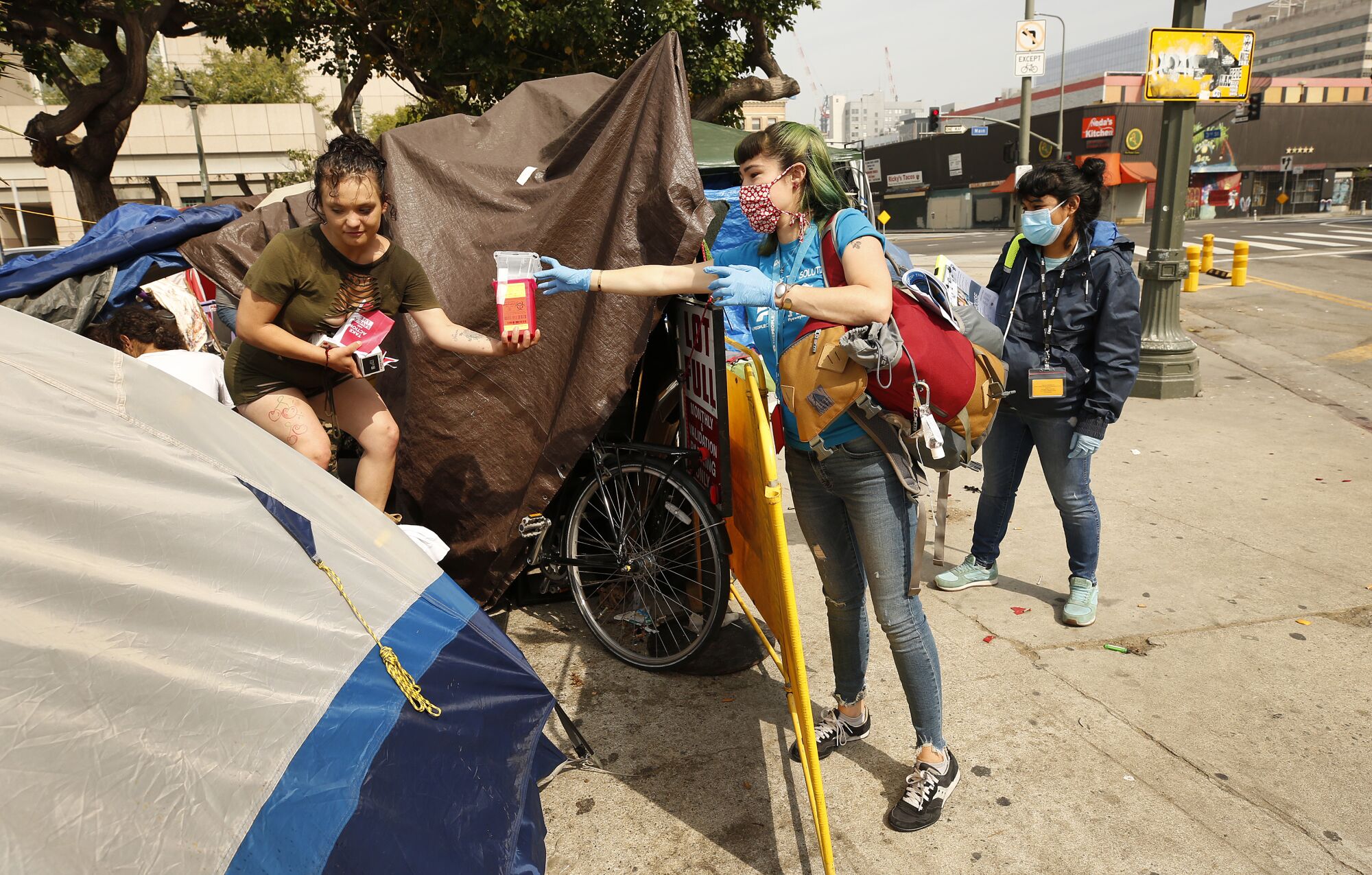 Outreach worker Ciara DeVozza, right, talks with 20-year-old homeless woman on the streets of skid row in Los Angeles