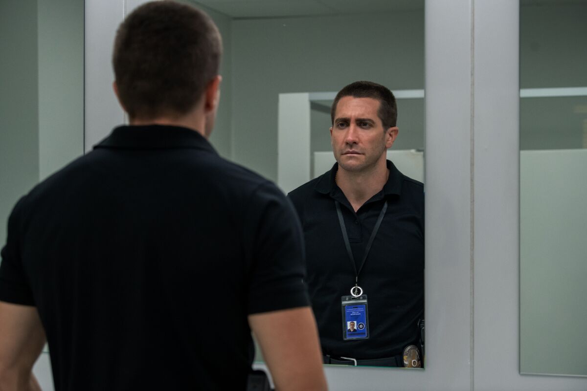 Jake Gyllenhaal looks at himself in a mirror in “The Guilty”