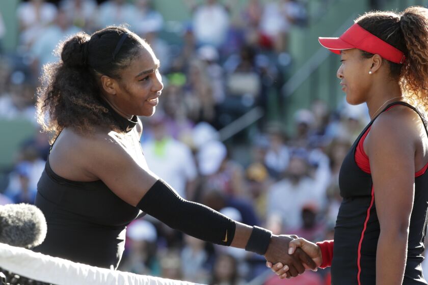 Naomi Osaka, right, shakes hands with Serena Williams after winning their Miami Open match March 21, 2018.