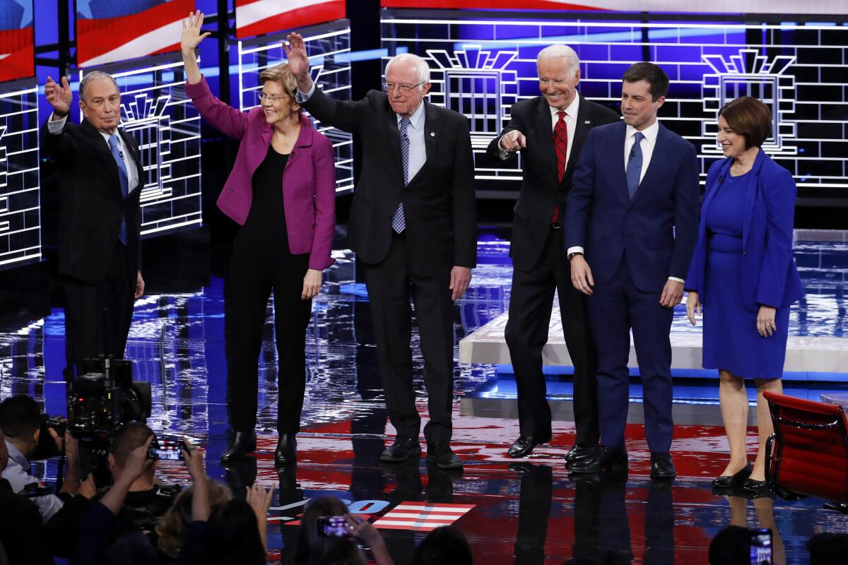 Michael R. Bloomberg, left, took to the Democratic debate stage for the first time Wednesday night.