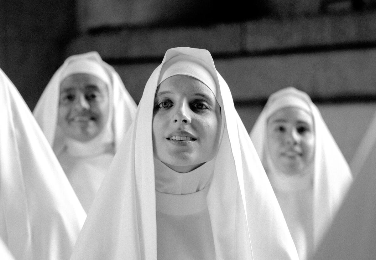 Three nuns gaze serenely toward the camera, smiling.