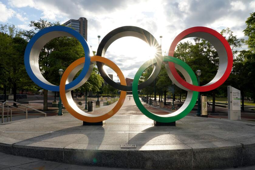 The Olympic rings are seen at the entrance to a mostly deserted Centennial Park in Atlanta, Georgia on April 24, 2020. - Governor Brian Kemp has eased restrictions allowing some businesses such as hair and nail salons to reopen today in the US state of Georgia after a four-week lockdown to stop the spread of the coronavirus. (Photo by Tami Chappell / AFP) (Photo by TAMI CHAPPELL/AFP via Getty Images)