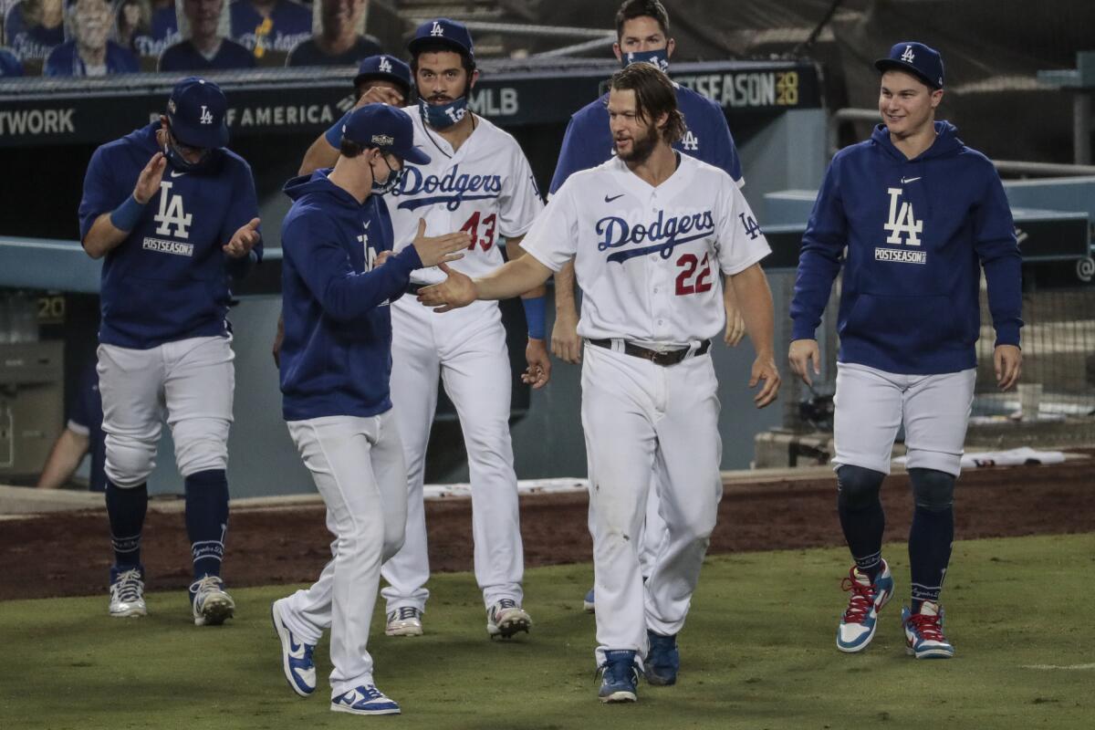Dodgers starting pitcher Clayton Kershaw is congratulated by teammate Walker Buehler.