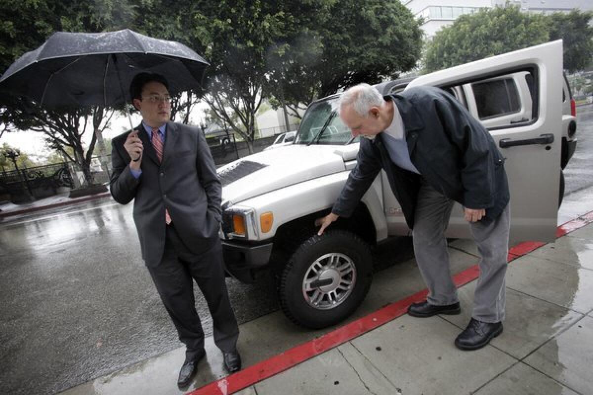 A 2010 photo shows Jaime de la Vega, left, then deputy mayor of Los Angeles, standing next to his Hummer SUV as Los Angeles Times columnist Steve Lopez examines the vehicle.