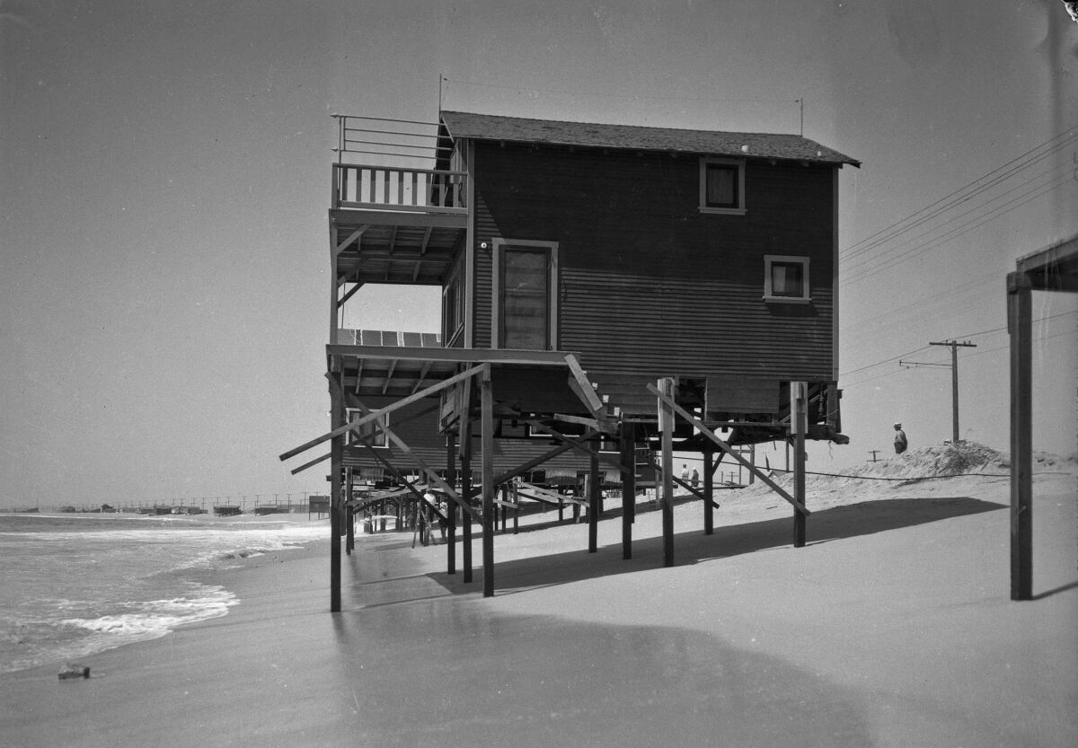 A beach house on stilts at water’s edge at Newport Beach. 