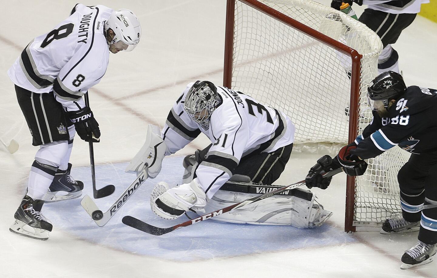 Kings goalie Martin Jones, who replaced Jonathan Quick, covers a rebound between defenseman Drew Doughty and Sharks winger Brent Burns after blocking a shot in the third period.