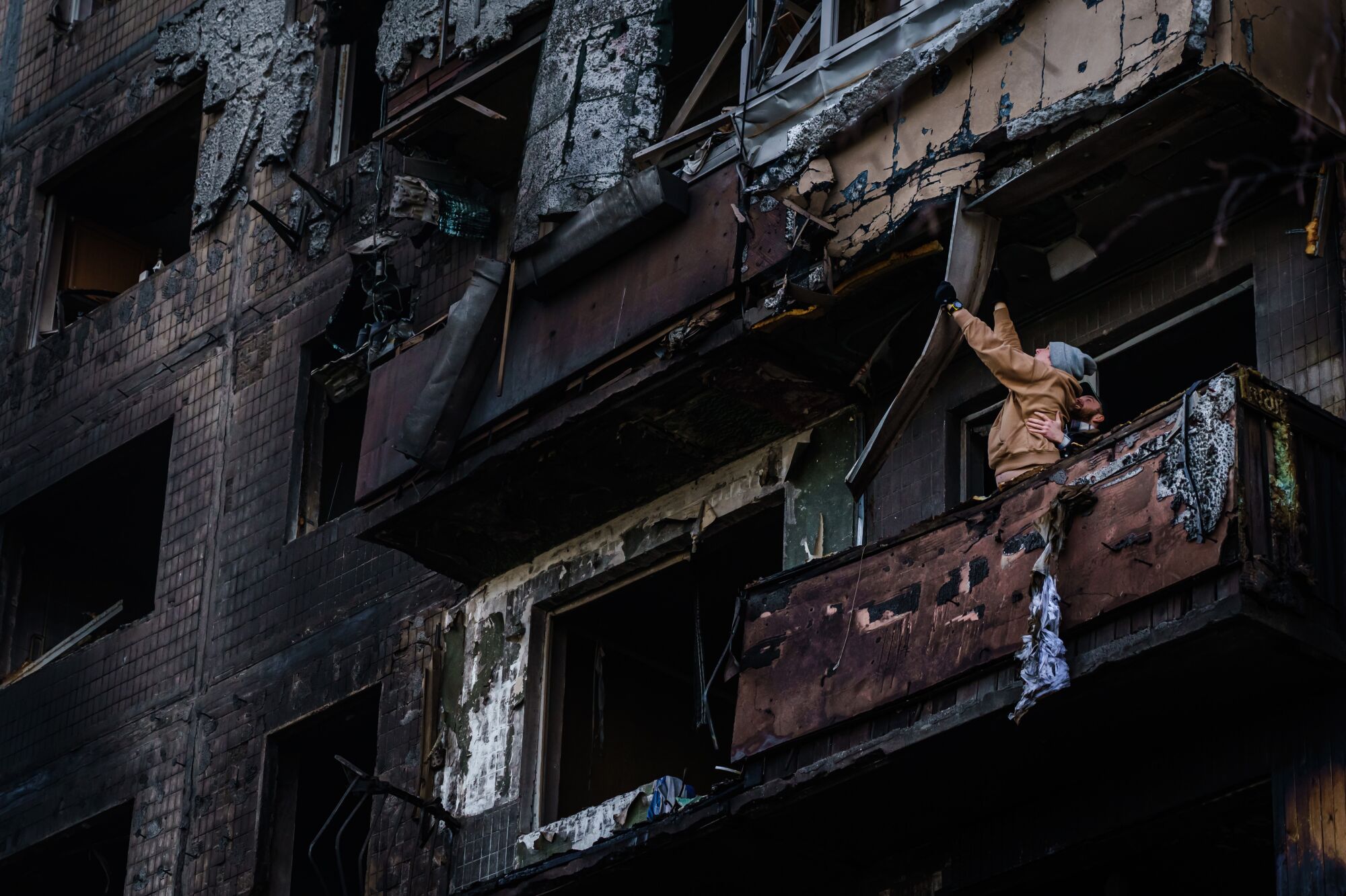 Residentes limpian los escombros en una sección quemada de un edificio dañado en el barrio Obolon de Irpin, Ucrania.