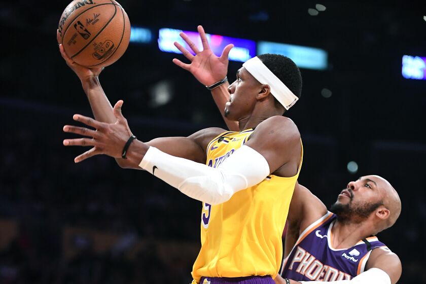 LOS ANGELES, CALIFORNIA FEBUARY 10, 2020-Lakers Rajon Rondo beats Suns Jevon Carter to score a basket in the 3rd quarter at the Staples Center Monday. (Wally Skalij/Los Angeles Times)