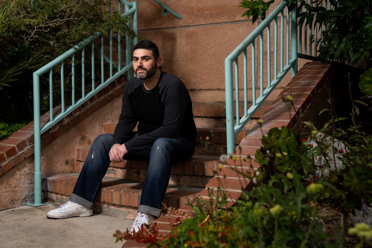 Arno Safarian sits on the steps outside of the Burbank apartment he shares with his parents.
