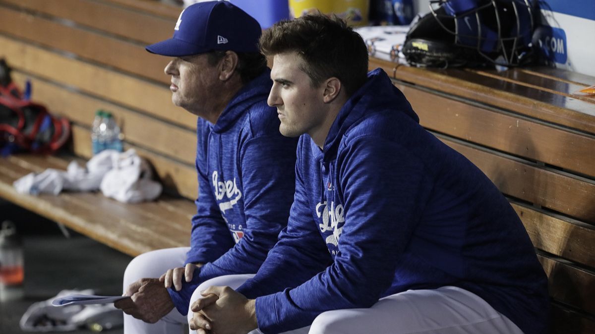 Dodgers pitcher Walker Buehler sits with pitching coach Rick Honeycut after throwing five scoreless innings against the Miami Marlins on Monday.