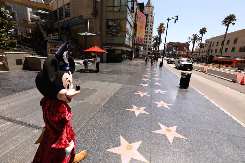 HOLLYWOOD, CA - JULY 28, 2020 - - Street performer Javei Rubio, dressed as Mickey Mouse, looks for customers to pose for photos on a deserted section of Hollywood's Walk of Fame in Hollywood on July 28, 2020. The COVID-19 pandemic has changed the landscape in LA's Hollywood/Highland corridor. (Genaro Molina / Los Angeles Times)