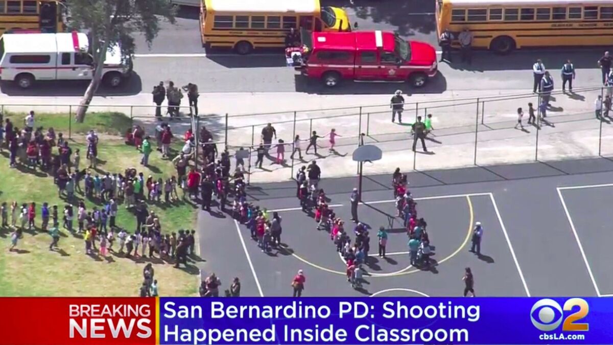 In this frame grab from video provided by KTTV Fox 11 and KCBS-TV, children are evacuated to school buses to be reunited with their parents at another location after a shooting inside North Park Elementary School in San Bernardino on Monday.