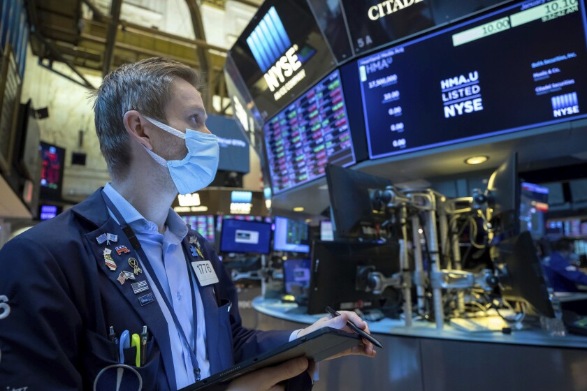In this photo provided by the New York Stock Exchange, trader Colby Nelson works on the floor, Friday, Jan. 21, 2022. Stocks wobbled between gains and losses on Wall Street Friday as major indexes head for another weekly loss. (Courtney Crow/New York Stock Exchange via AP)
