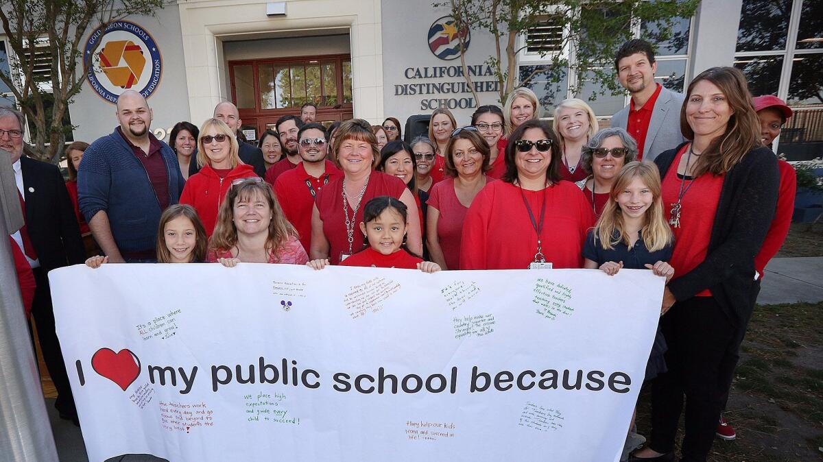 Teachers, students and administrators pose with a banner in front of George Washington Elementary School in Burbank as part of the California Teachers Assn.'s “Day of Action.”