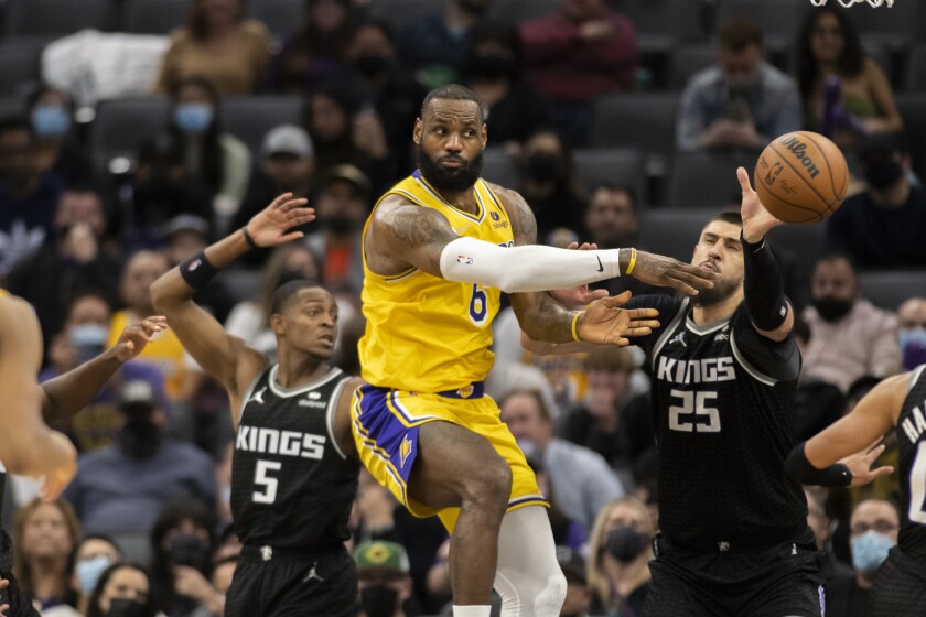 Los Angeles Lakers forward LeBron James (6) passes off while defended by Sacramento Kings guard De'Aaron Fox (5) and center Alex Len (25) in the second half of an NBA basketball game in Sacramento, Calif., Wednesday, Jan. 12, 2022. The Kings won 125-116. (AP Photo/José Luis Villegas)