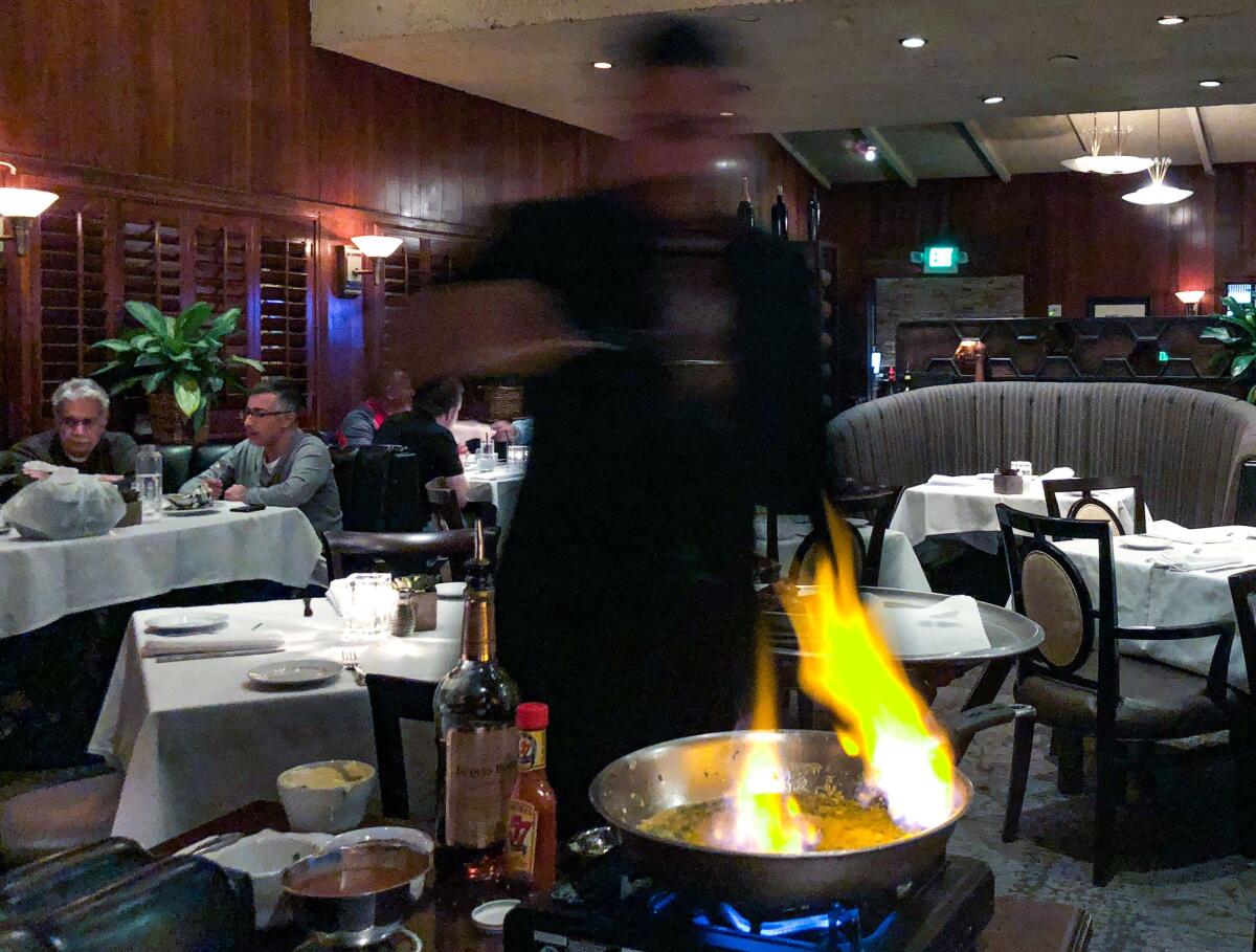 A server prepares steak Diane tableside at Dal Rae