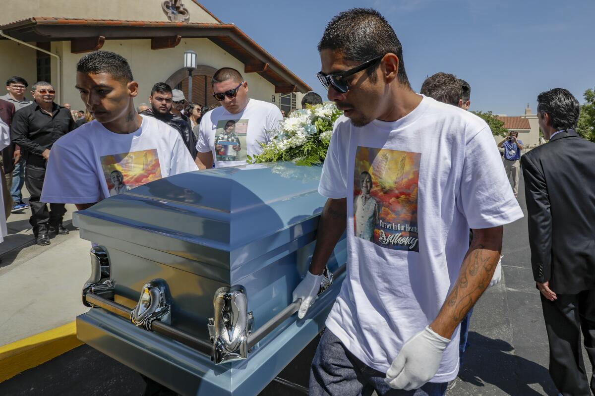 Victor Avalos, right, father of Anthony Avalos, and other family member bring out the casket after funeral services.