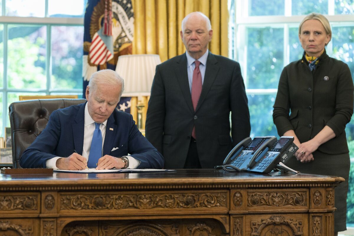 President Joe Biden signs the Ukraine Democracy Defense Lend-Lease Act of 2022 in the Oval Office of the White House, Monday, May 9, 2022, in Washington. Witnessing the signing are Ukraine-born Rep. Victoria Spartz, R-Ind., right, and Sen. Ben Cardin, D-Md. (AP Photo/Manuel Balce Ceneta)